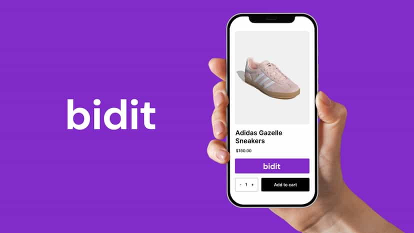 Hand holding a smartphone showing a product page with a ‘Bidit’